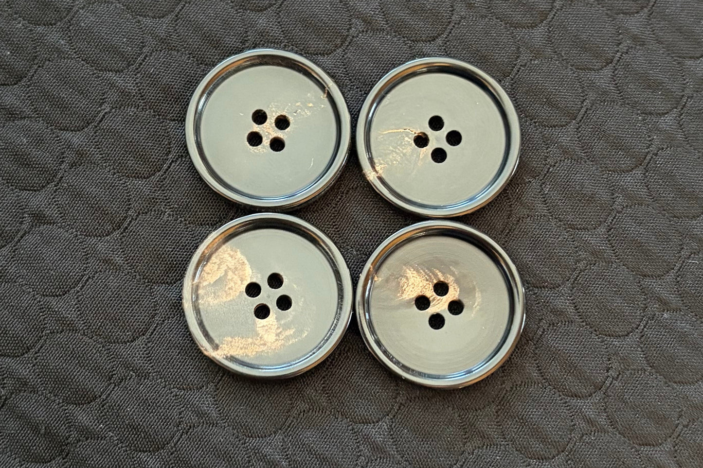 Set of polished black buttons on a textured black surface