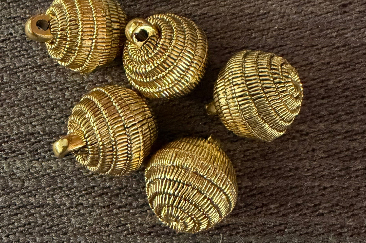 Gold decorative buttons on a brown textured surface
