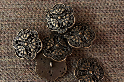 Bronze decorative buttons on a textured brown surface