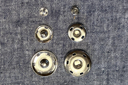 Metal buttons on a textured fabric background
