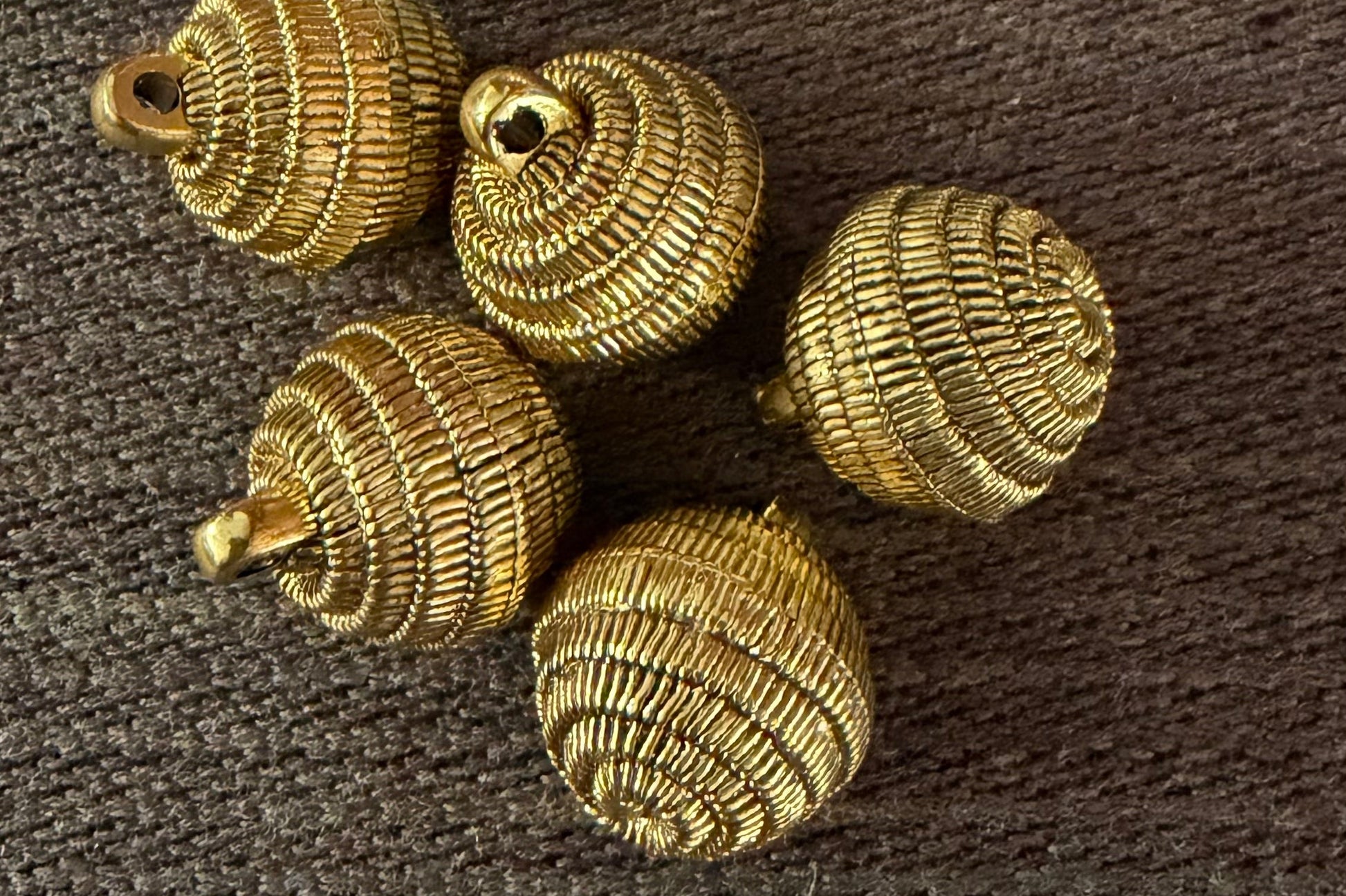Gold decorative buttons on a brown textured surface