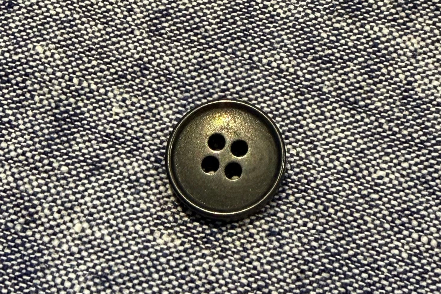 Close-up of a button on gray fabric
