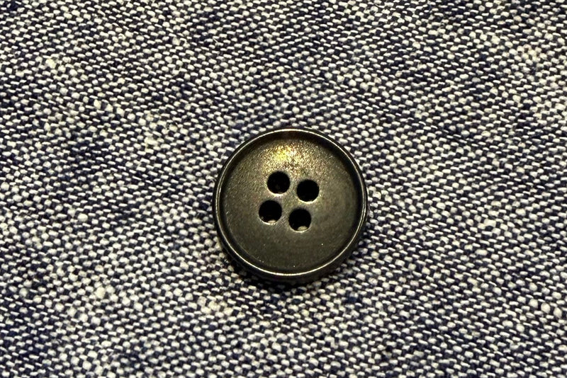 Close-up of a button on gray fabric