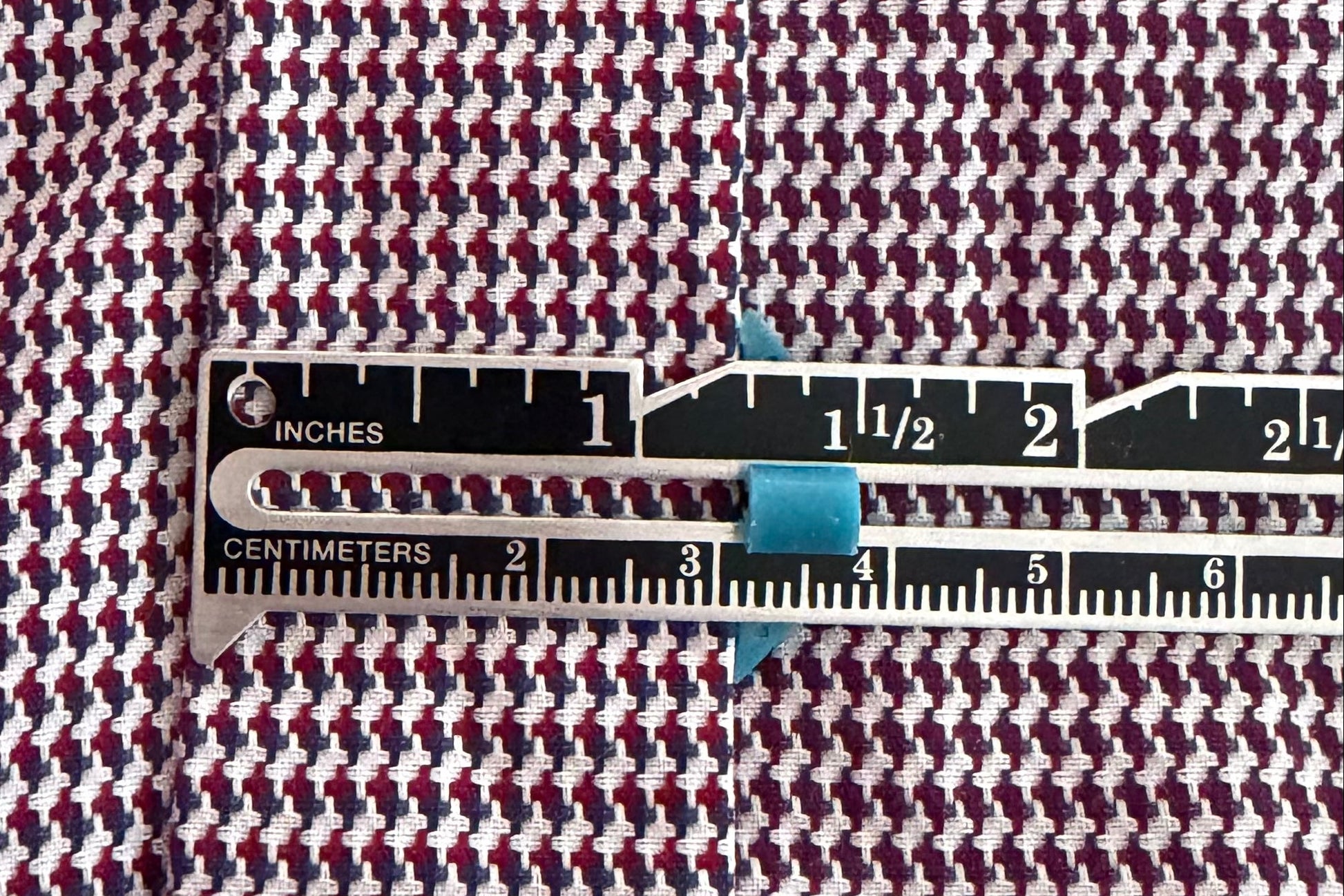 Houndstooth pattern fabric with a ruler measuring hem width.
