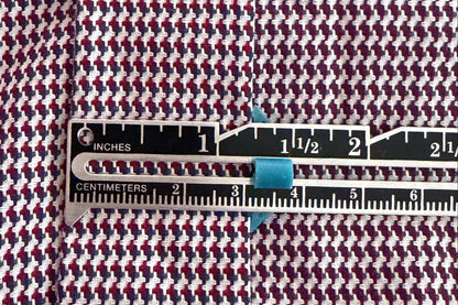 Houndstooth pattern fabric with a ruler measuring hem width.