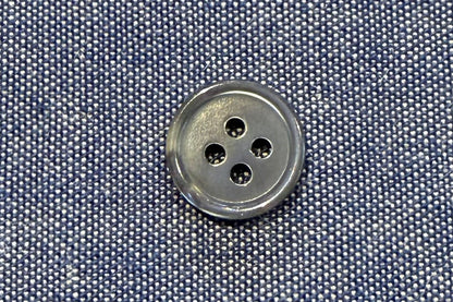 Close-up of a button on blue fabric with a textured background