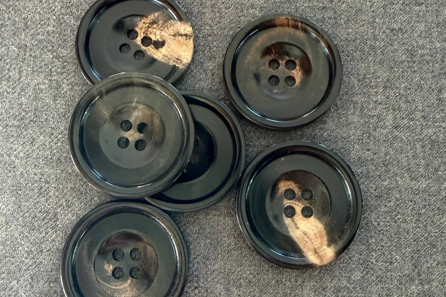 Set of black buttons with golden highlights on a gray surface