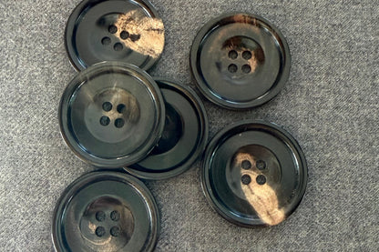 Set of black buttons with golden highlights on a gray surface