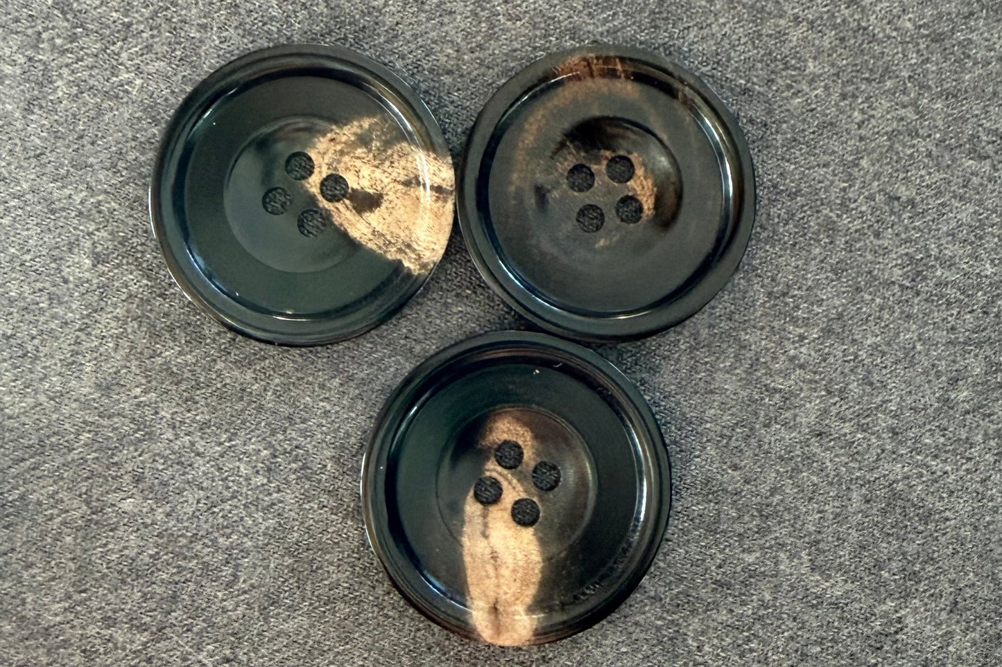 Three black buttons on a gray surface