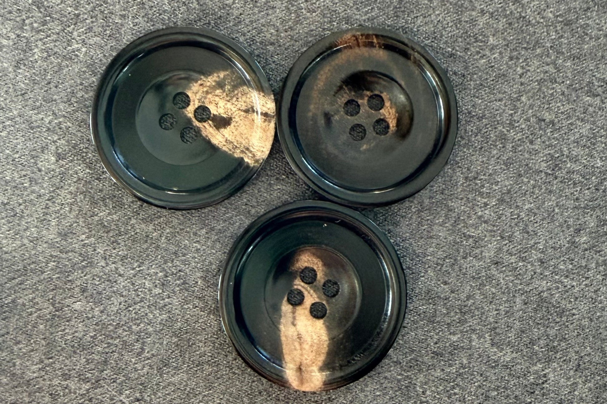 Three black buttons on a gray surface