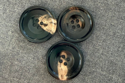 Three black buttons on a gray surface