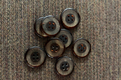 Brown and clear buttons on a textured fabric surface