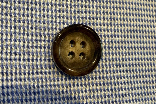 brown button on blue and white fabric