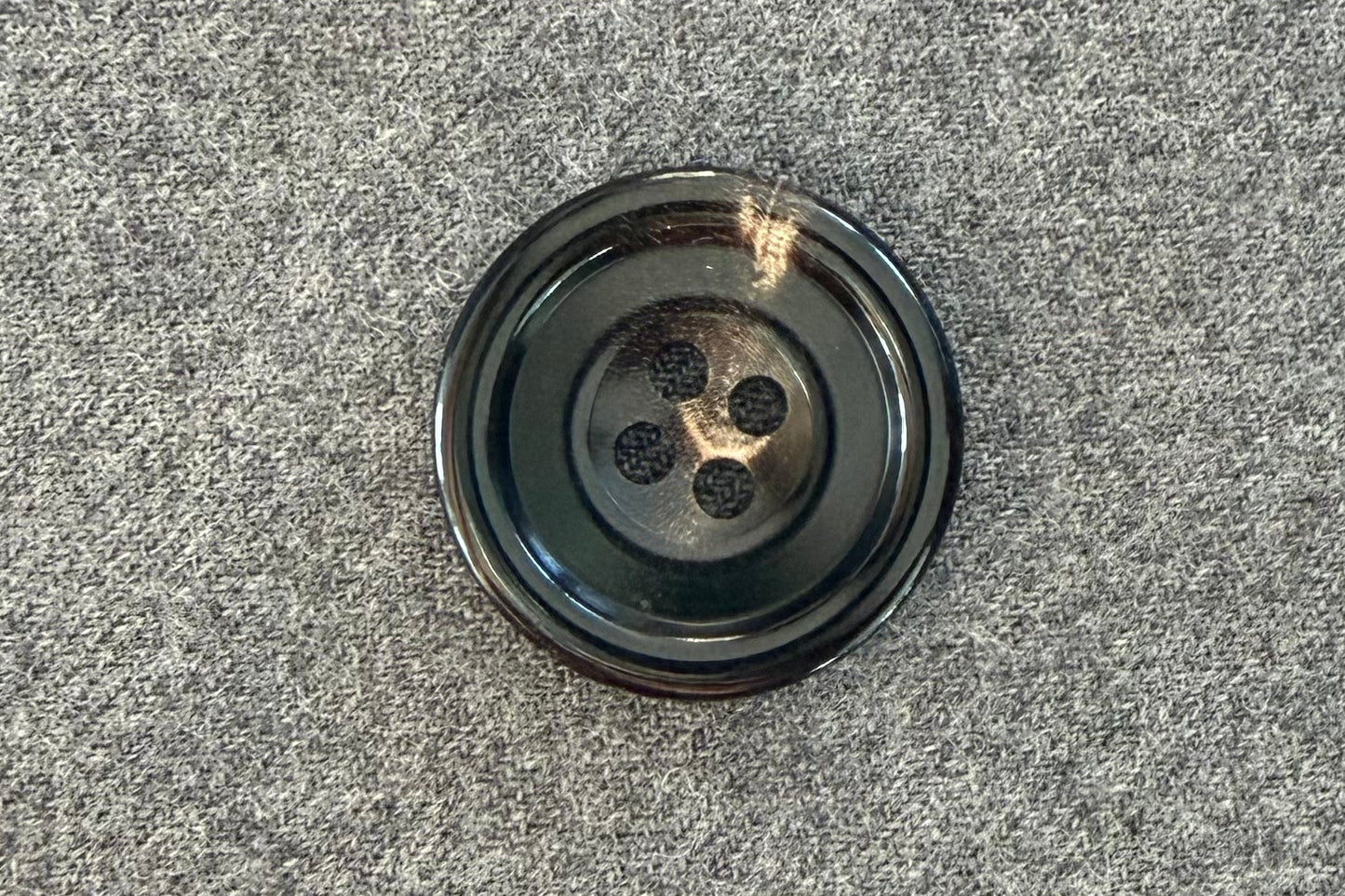 Black button on a textured gray surface