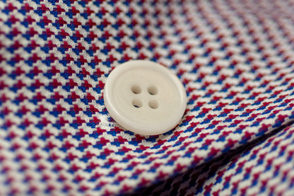 Close-up of a white button on a red and blue checkered fabric