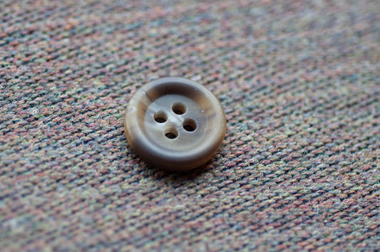 Brown button on a textured fabric background