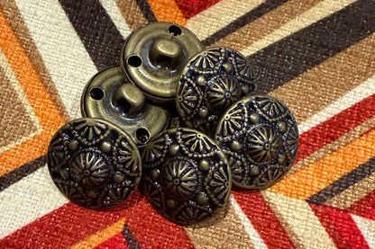 Decorative metal buttons 
on a patterned fabric background