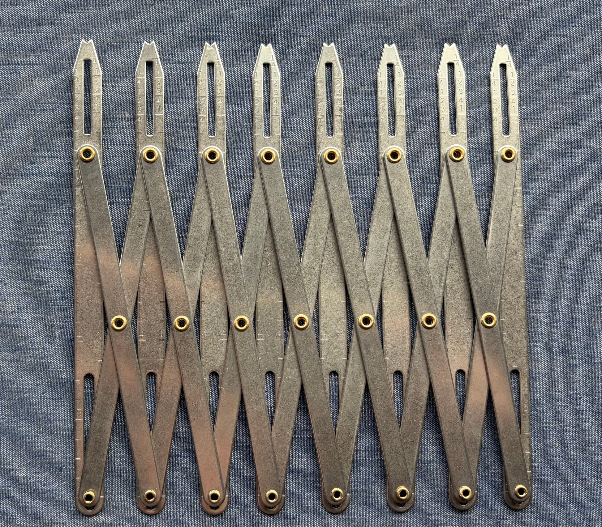 An accordion-like sewing gauge on blue fabric.