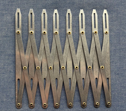 An accordion-like sewing gauge on blue fabric.