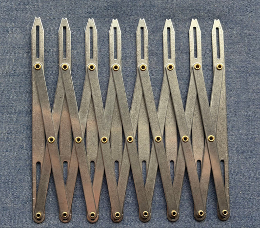 An accordion-like sewing gauge on blue fabric.