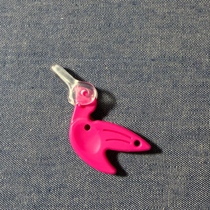 Pink bird-shaped needle-threader on a gray background