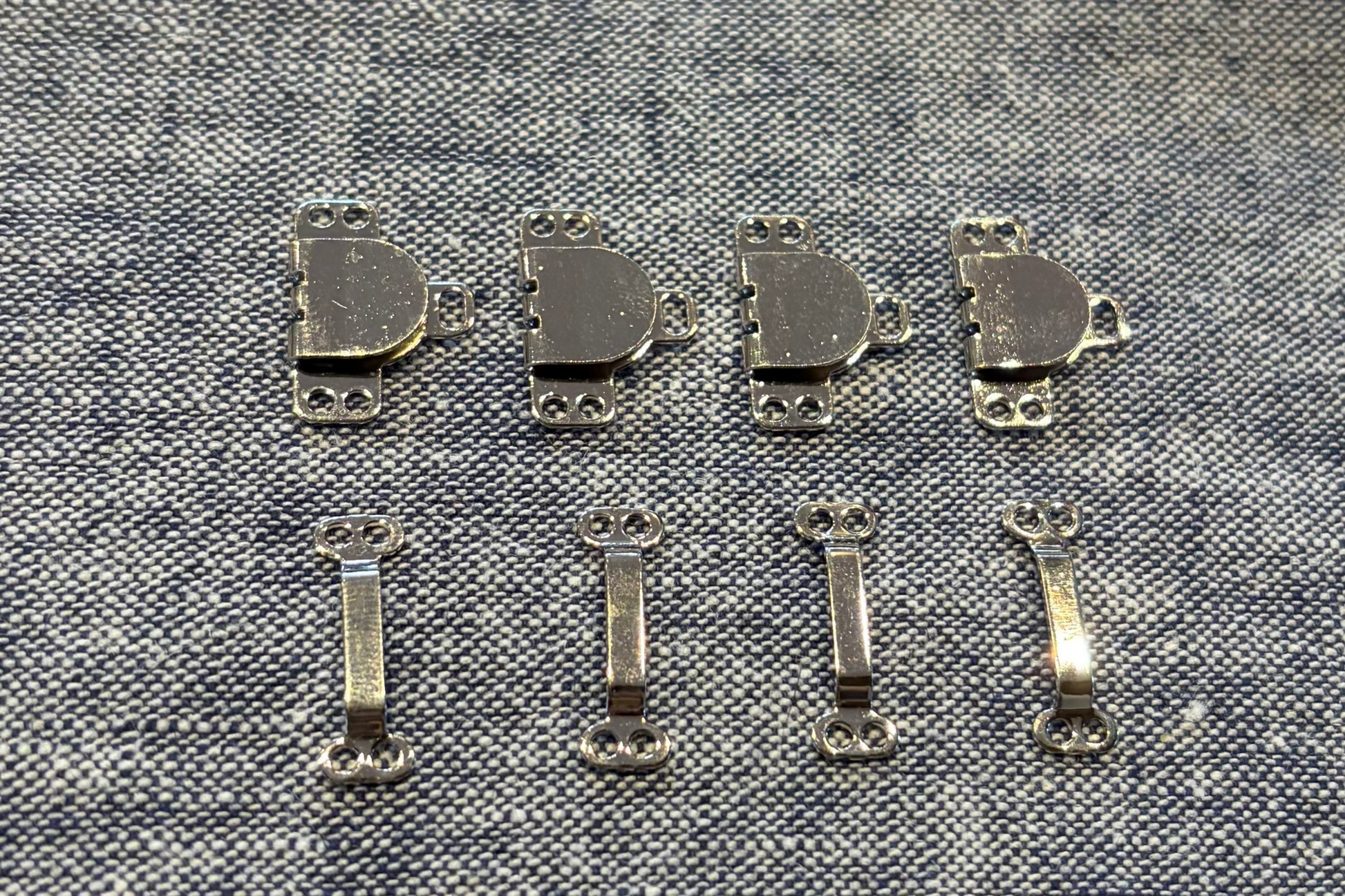 Four sets of hook and eyes on fabric background