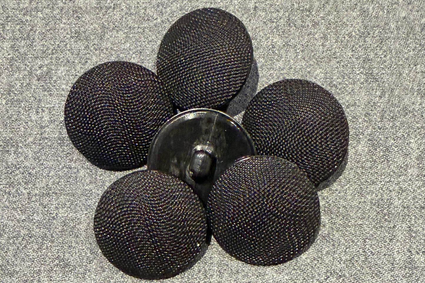 Black mesh buttons on a gray surface