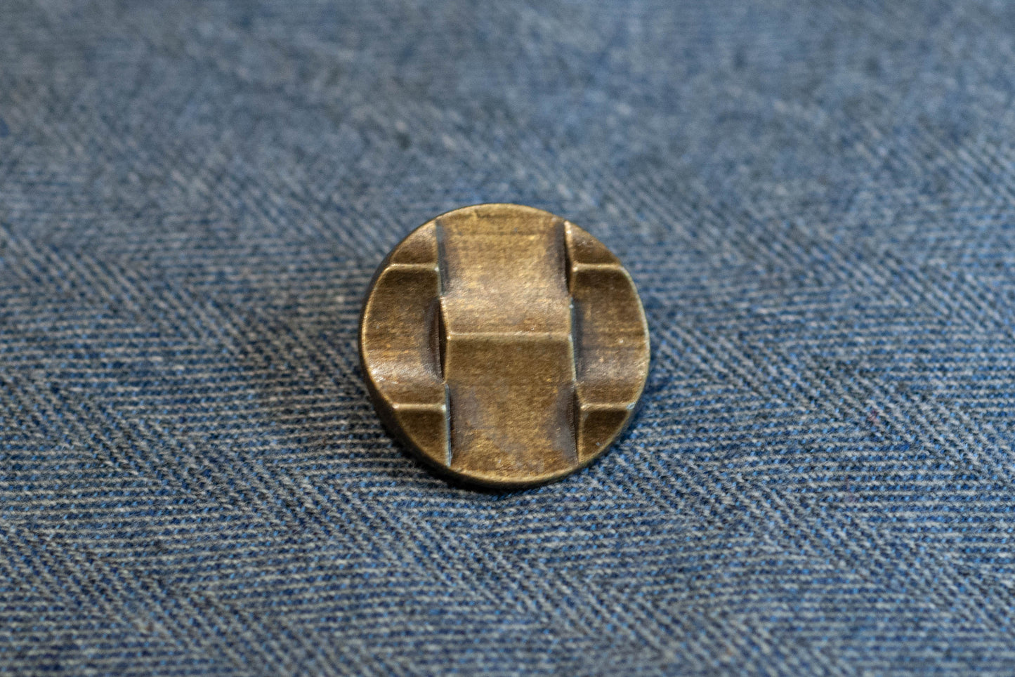 Bronze button on a denim fabric background