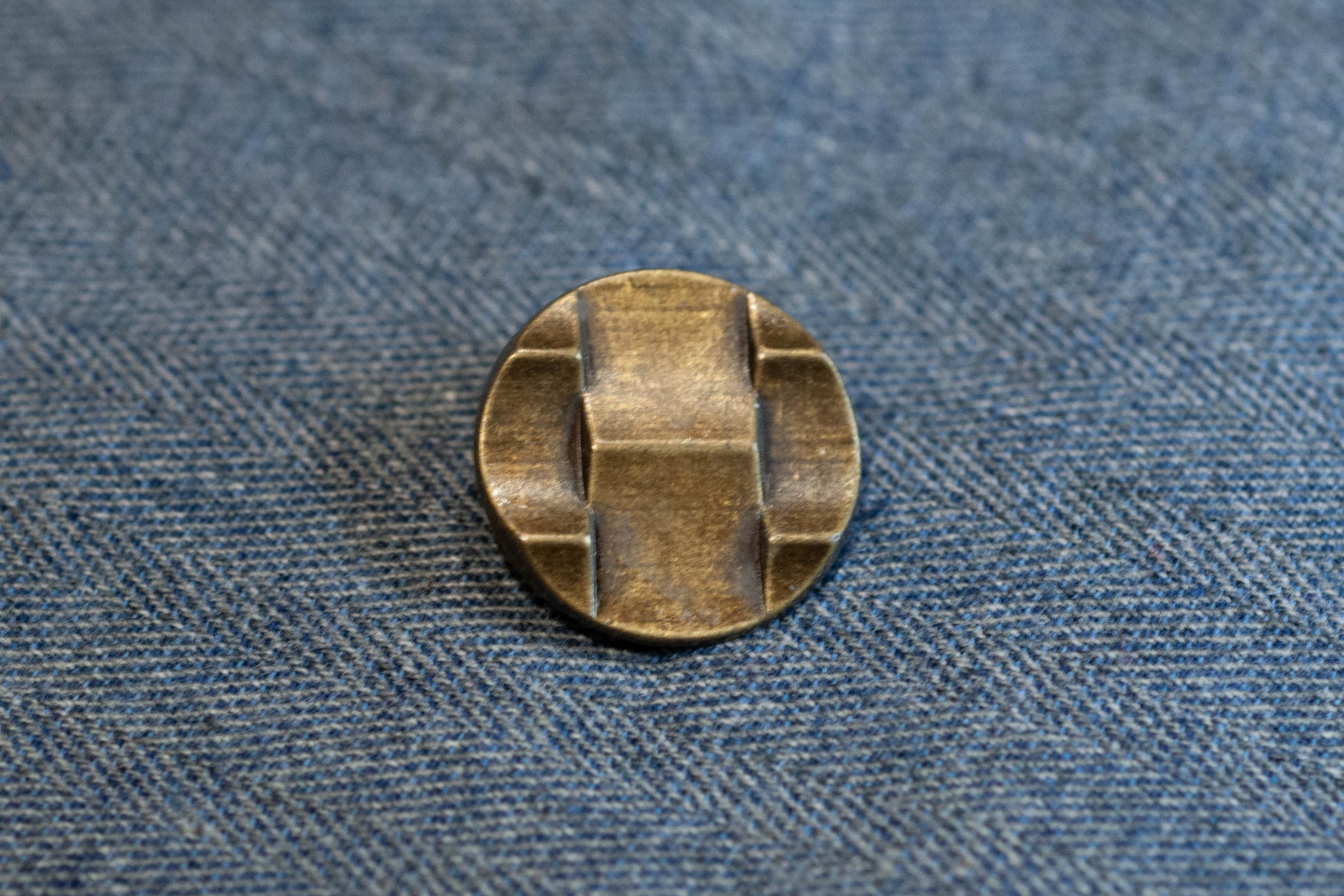 Bronze button on a denim fabric background